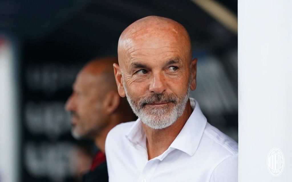 Stefano Pioli in panchina con la camicia bianca abbozza un sorriso