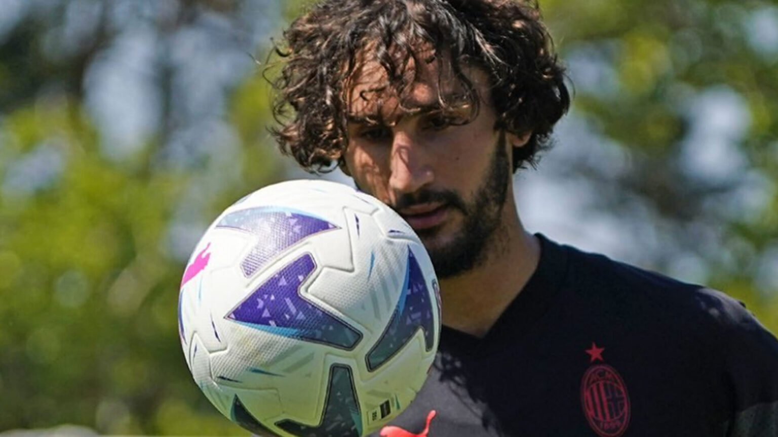 Yacine Adli con un pallone davanti alla faccia