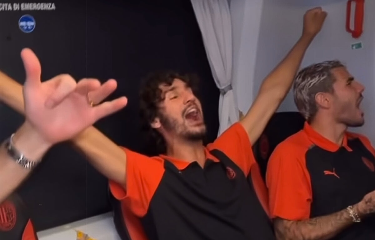 Yacine Adli canta sul pullman insieme ai compagni di squadra, il Milan ha appena vinto 2-1 sul campo della Roma.